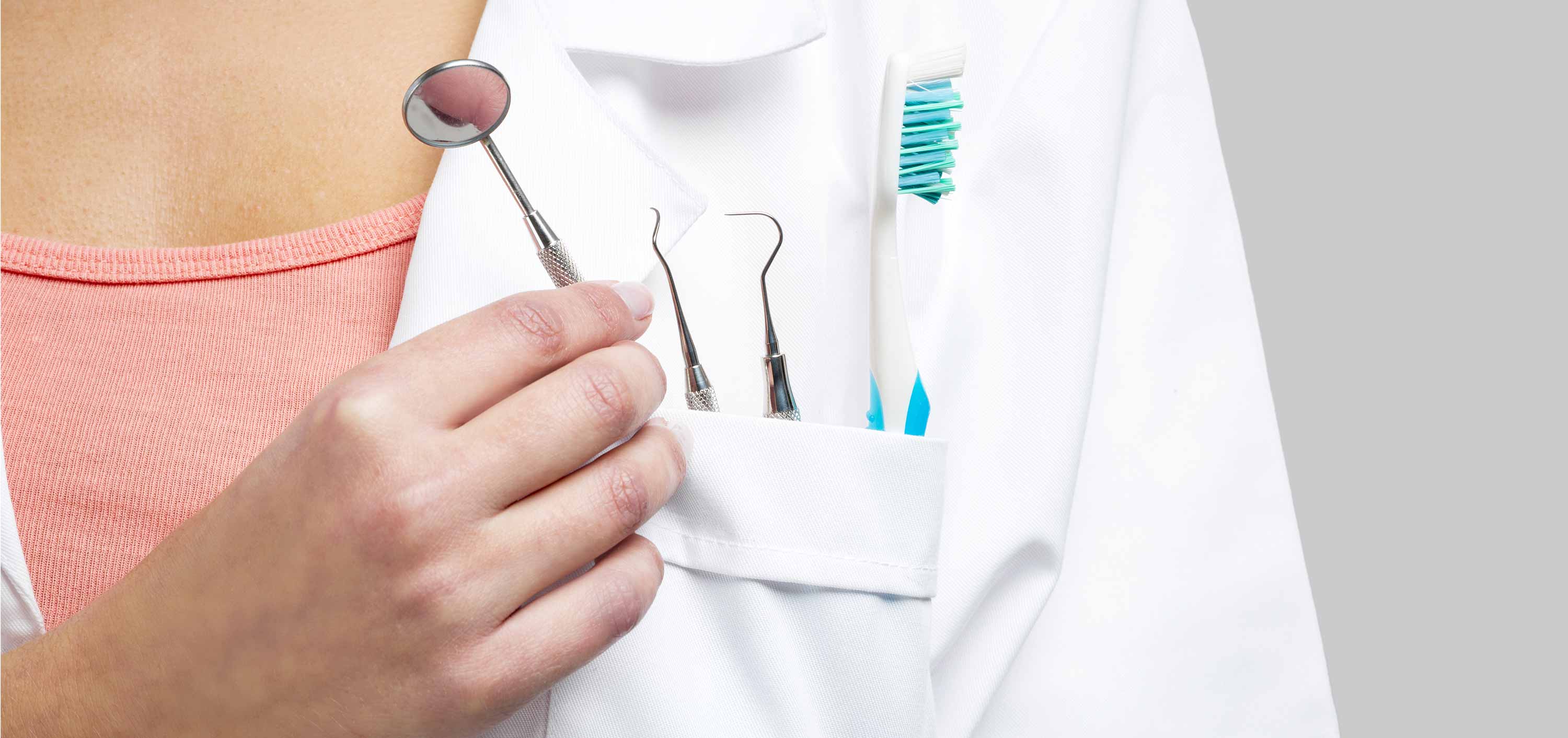 Dentist placing dental equipment in their white coat pocket